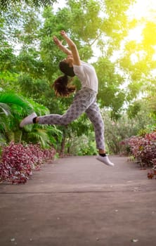 Girl jumping surrounded by trees, concept of happy girl jumping