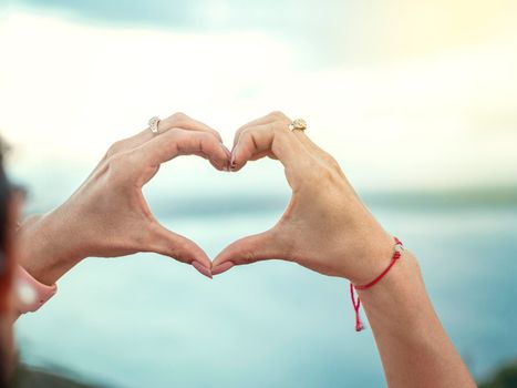 Hands together in a heart shape, woman's hands together in a heart shape, hands making a heart shape