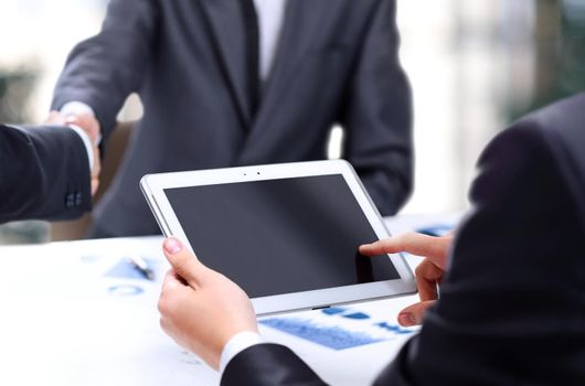 Close-up of a modern business team using tablet computer to work