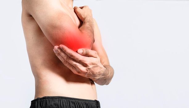 Person with elbow pain, concept of a man with rheumatism elbow pain, man massaging sore elbow, man with elbow cramp