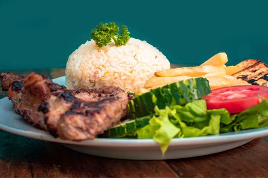 Close up of roasted chicken with gallo pinto and pico de gallo, Nicaraguan food served on wooden background, Plate with roast chicken and rice served on wooden background