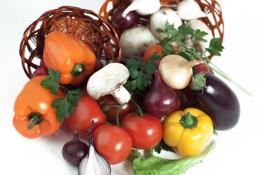 closeup.mushrooms and fresh vegetables in a wicker basket.isolated on a white background