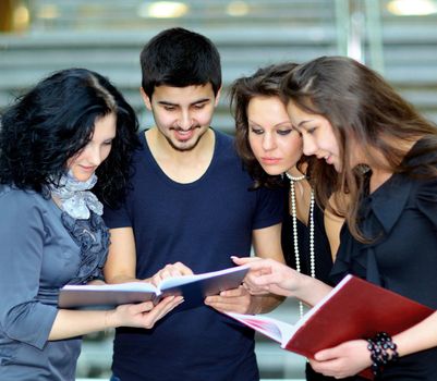 Group of students talking and holding notebooks