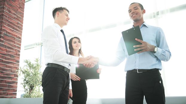 handshake of business partners standing in the office.the business concept