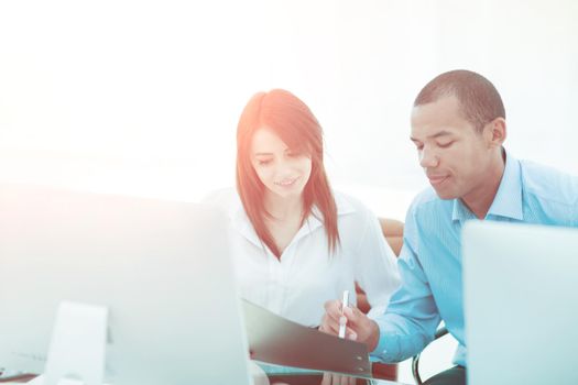 employees discussing financial documents sitting at a Desk .photo with copy space