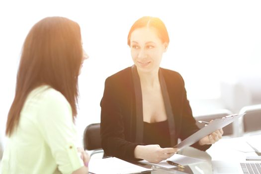 two business women discussing documents.