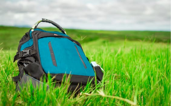 A backpack on the green grass, close up of a backpack on the grass