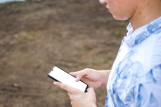 Close up of a man with cell phone in hand, close up shot of a person checking his cell phone, young guy with cell phone in hand with copy space