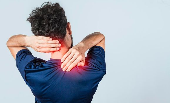 Close up of person with shoulder and neck problems, sore man touching his shoulder on isolated background, lumbar and muscular problems concept