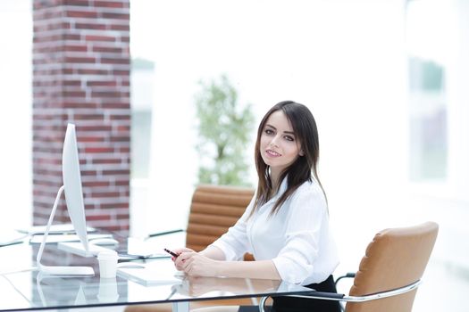 confident business woman sitting behind a Desk.photo with copy space