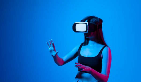 Amazed woman getting experience using glasses of virtual reality and exploring a virtual world. Girl spend shes time in metaverse while hanging out with a friends