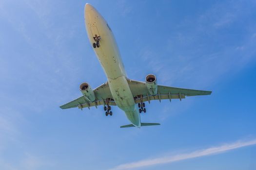 Coronavirus is over. Quarantine weakened. Take off the mask. Now you can travel. A white airplane flying in a clear pale blue sky.