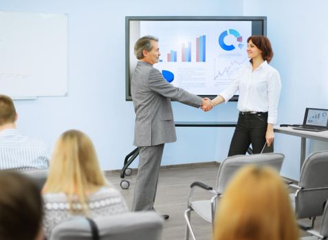 business partners shake hands after a successful presentation