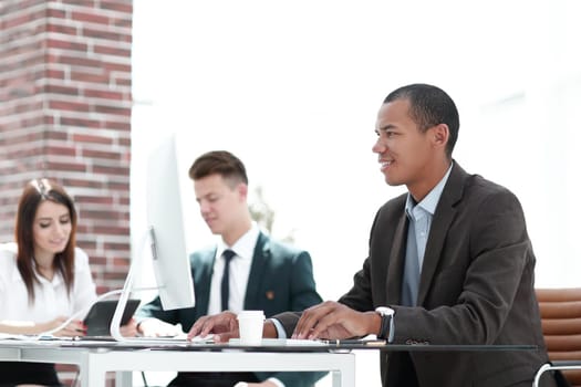 young businessman sitting behind a Desk in a modern office.photo with copy space