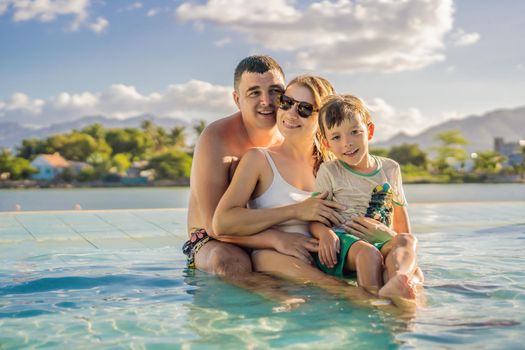 Luxury resort swimming pool. Happy family tourists relaxing in holiday retreat on summer travel vacation enjoying ocean background.