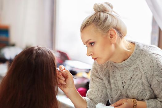 Professional makeup artist apply makeup beautiful girls for the holiday.