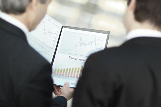 rear view.closeup of business partners discussing financial documents.business concept