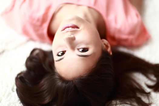 Relaxed woman lying on the floor indoors and smiling