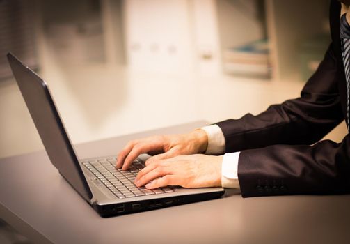 Person Typing on a modern laptop in an office