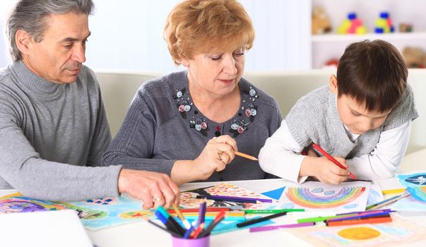 Grandmother, grandfather and grandson spend time together. Symbol of the family.