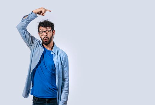 Surprised handsome man pointing to the side, Concept of latin man pointing a banner to the side, Surprised guy pointing a poster