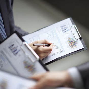 Close up of business people hands pointing growing financial business graph.