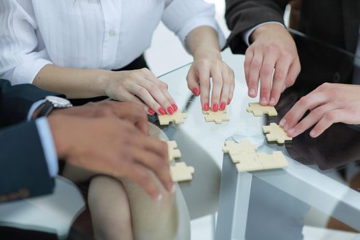 closeup. business team assembling puzzle pieces.concept business solutions