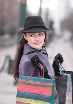 stylish woman with shopping bags showing credit card.