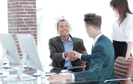 handshake business people behind a Desk in the office.the concept of partnership