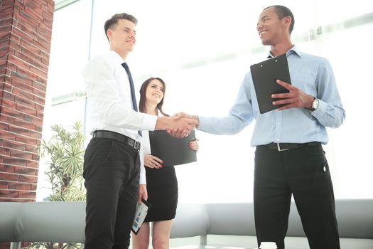 handshake of business partners standing in the office.the business concept