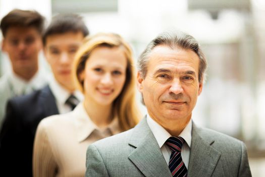 Happy smiling business team standing in a row at office