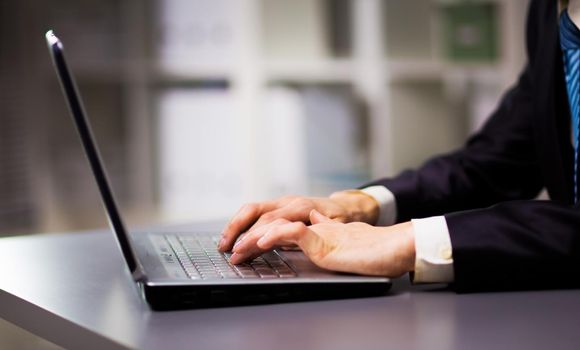 Person Typing on a modern laptop in an office