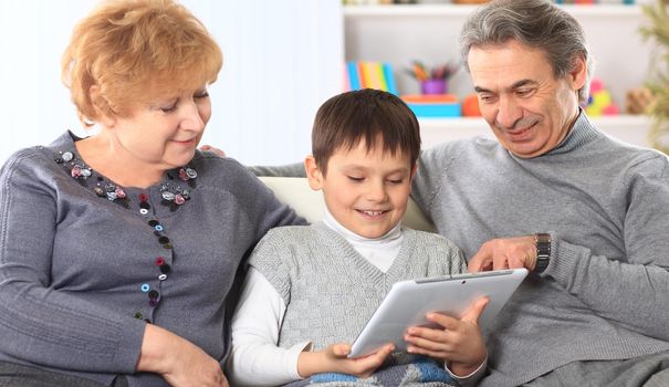 portrait of boy with their grandparents at home