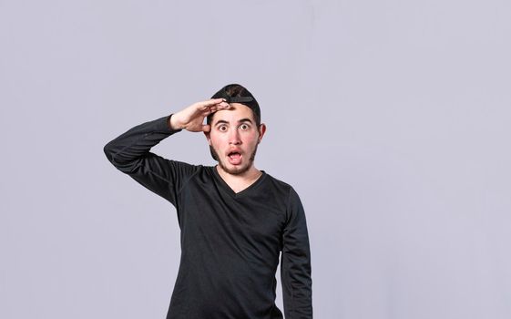 Amazed young man with his mouth open with his hand on his forehead, surprised guy with his mouth open with his hand on his forehead, concept of someone astonished