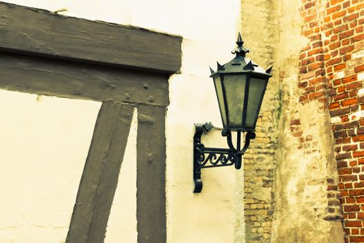 Vintage street lamp against old wall background. Riga, Latvia