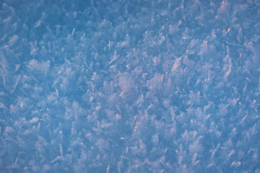 Snow texture with snowflakes close-up. Snow background for Christmas card or wallpaper. Blue macro image of an abstract snowdrift. Crystal snow minimal texture pure. Winter landscape background. High quality photo