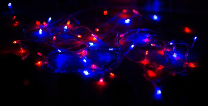 Christmas lights on dark background with copy space. Decorative garland