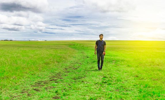 Adventurous man in the field, man with backpack in the field looking