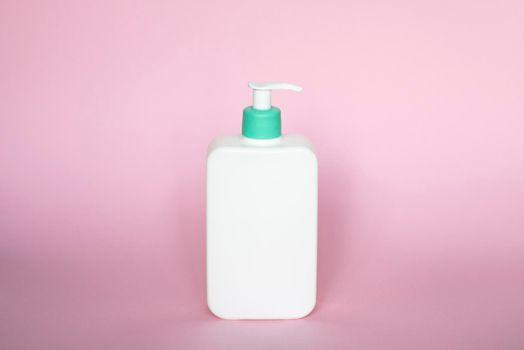 Liquid container for gel, lotion, cream, shampoo, bath foam. Cosmetic plastic bottle with dispenser pump on pink background. Cosmetic packaging mockup with copy space