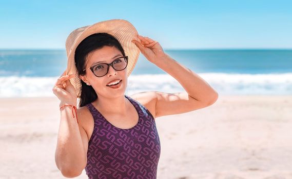 woman with hat happy on the beach, beach vacation concept