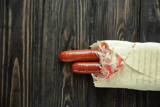 tender sausages in pita bread on wooden background.photo with copy space.