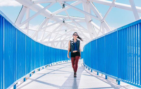 Urban girl walking on a bridge, portrait of an attractive girl on a bridge, Lifestyle of an attractive urban girl on a bridge, concept of a latin girl lifestyle