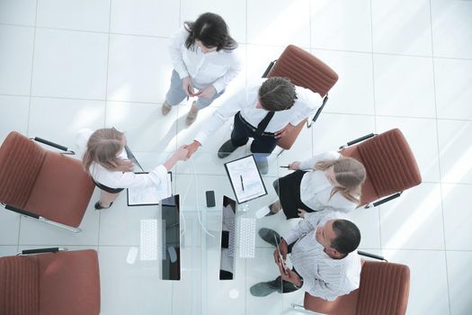 top view.the handshake business partners at a business meeting.photo with copy space