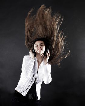 beautiful young woman listening to music with headphones .isolated on a black background. photo with copy space .