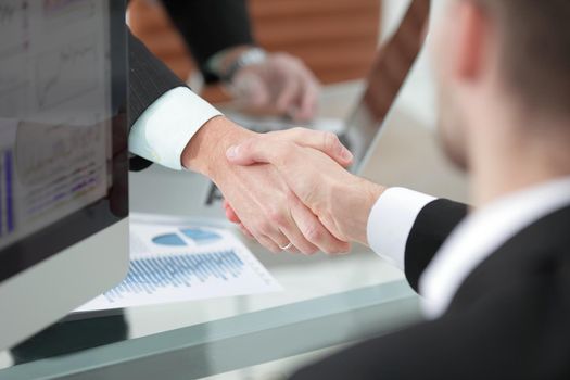 close up. handshake of business partners above the Desk.concept of partnership