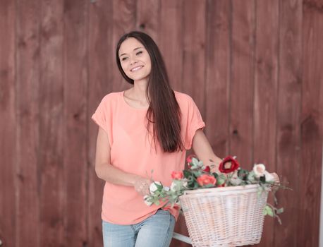 portrait of a young woman with Bicycle and spring flowers in a basket.