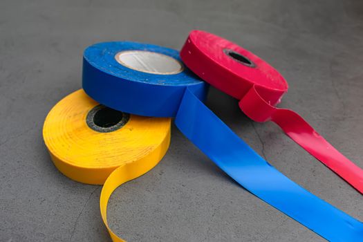 Three pieces of insulating adhesive tape in three colors for different purposes