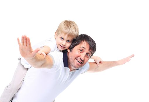 Confident father giving his son piggyback ride against a white background