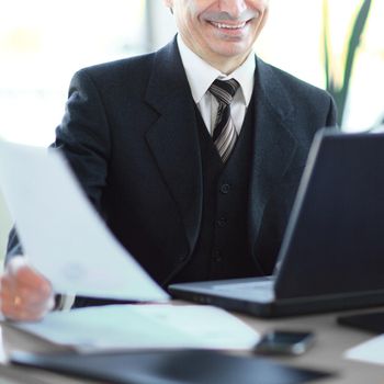 smiling senior businessman sitting at his Desk