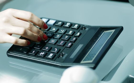 closeup.business woman using a calculator at the workplace.photo with copy space
